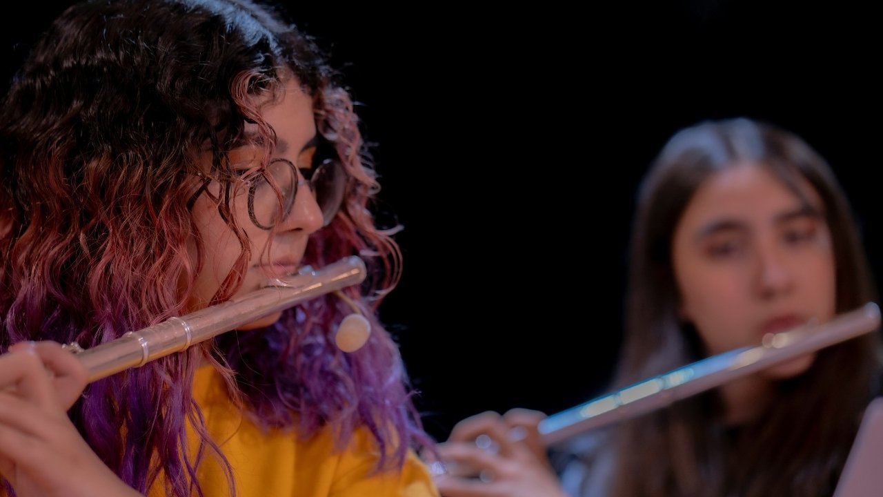 Two flute players performing the same melodic line in unison